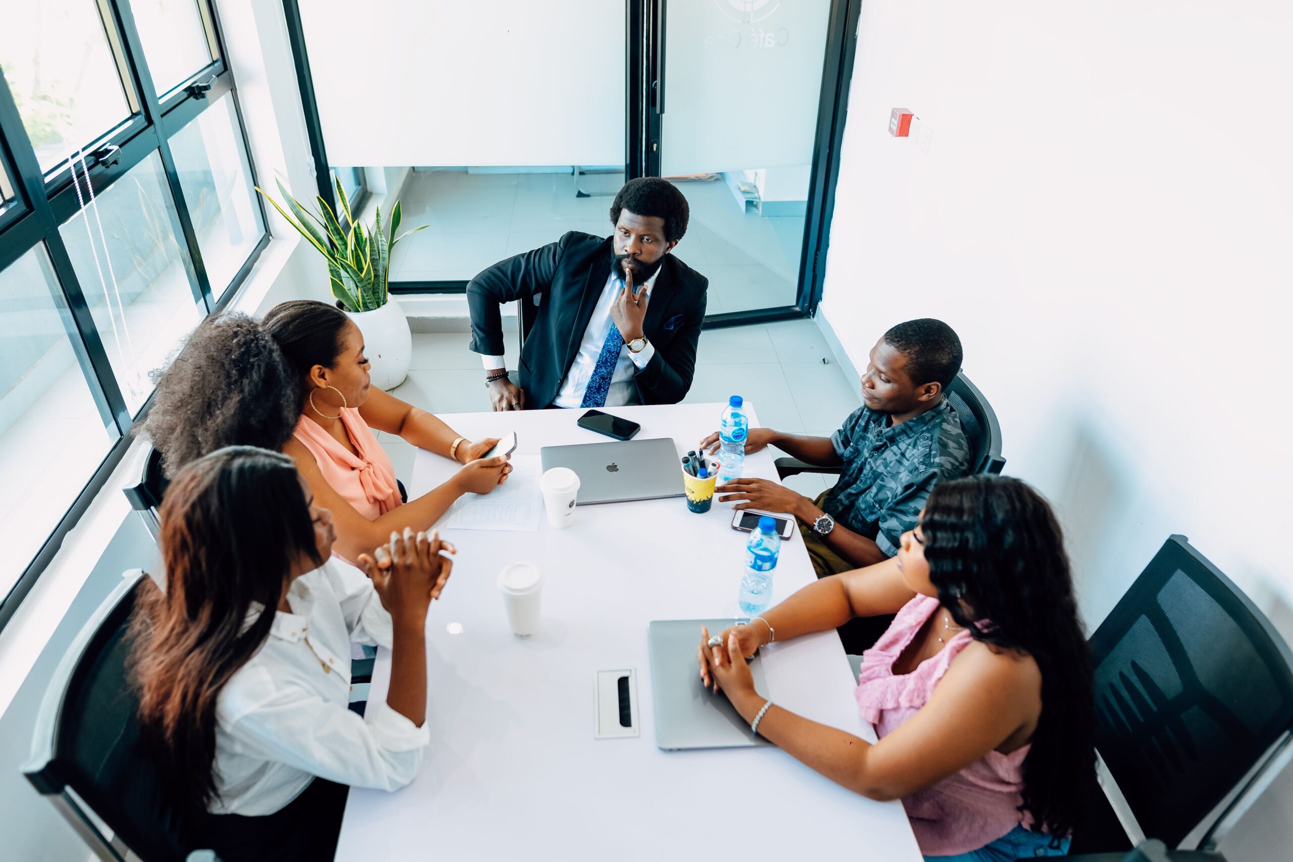 African leadership team discussing interconnected operational decisions in a Lagos office