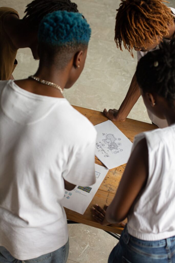 Black operations professionals reviewing performance documents during a daily management meeting
