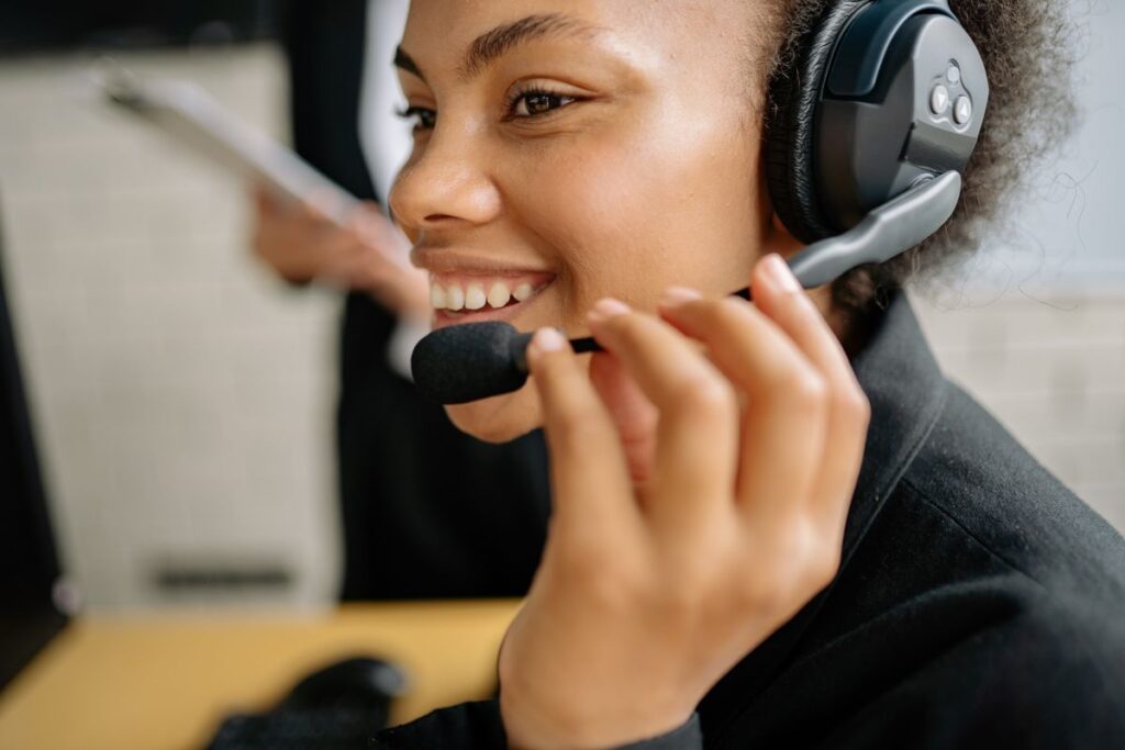 Black African customer service professional working with a headset at a service operations desk