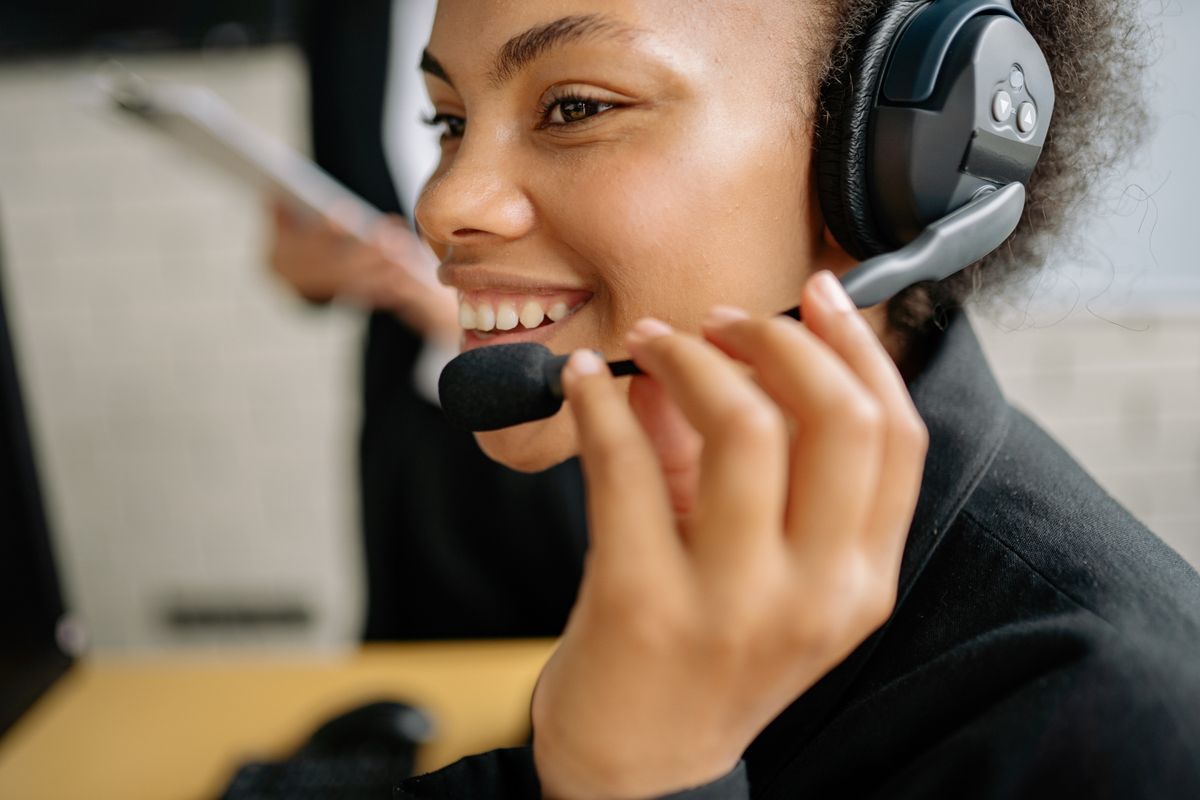Black African customer service professional working with a headset at a service operations desk