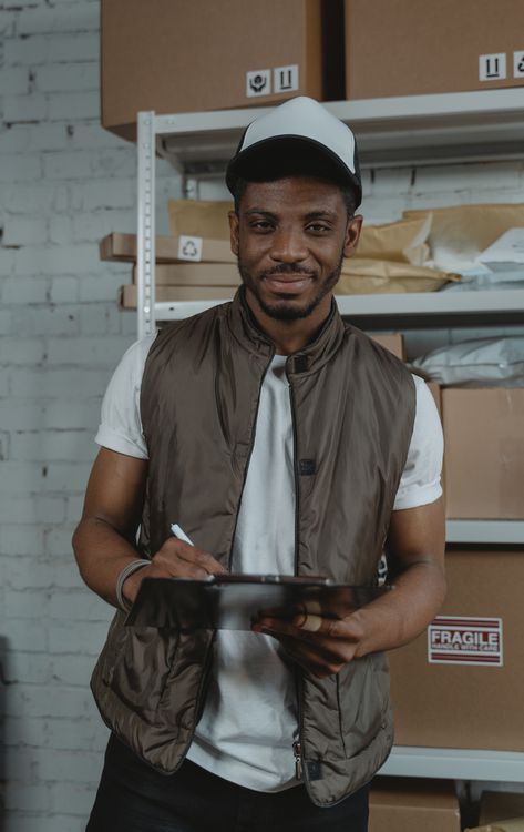 Black professional managing cartons and shipments in a warehouse